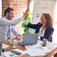 Business professionals celebrating in a meeting